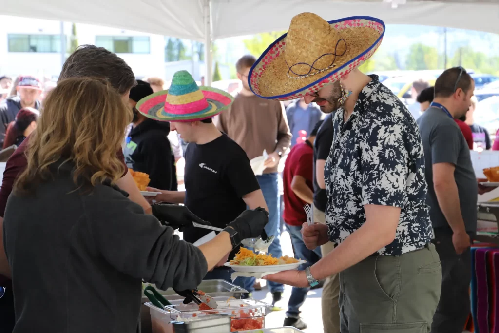 Employees getting served food wearing sombreros