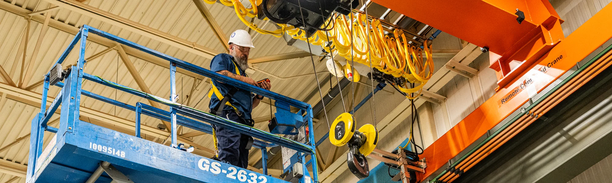 Patrick fixes a crane standing on a scissor lift