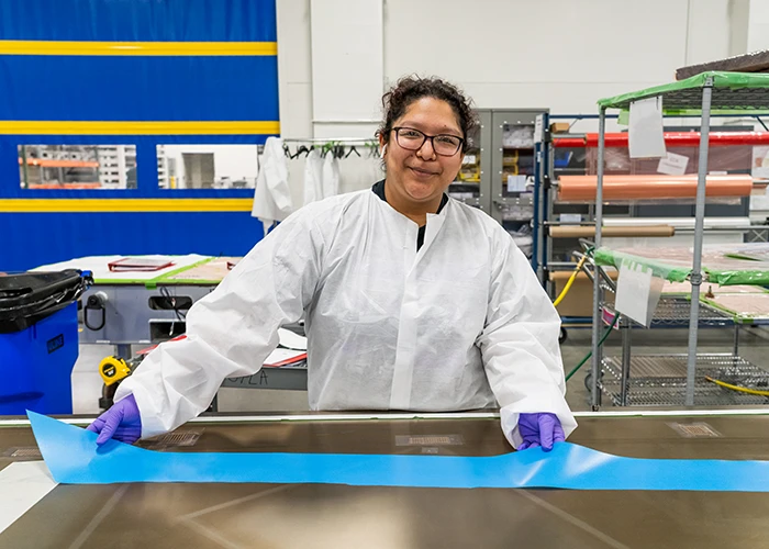 Melody lays up carbon fiber prepreg onto a tool