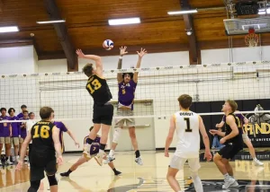 Cory spiking a volleyball over a net