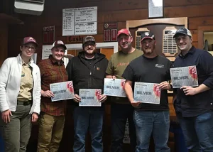 A Scouting America employee poses with Janicki Team 1 as they received the Silver award