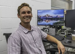 Luke, Engineering Intern, sits at computer 
