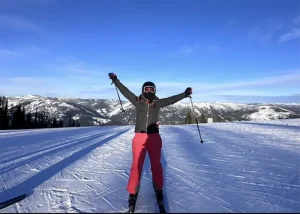 Quinn with her poles in the air skiing
