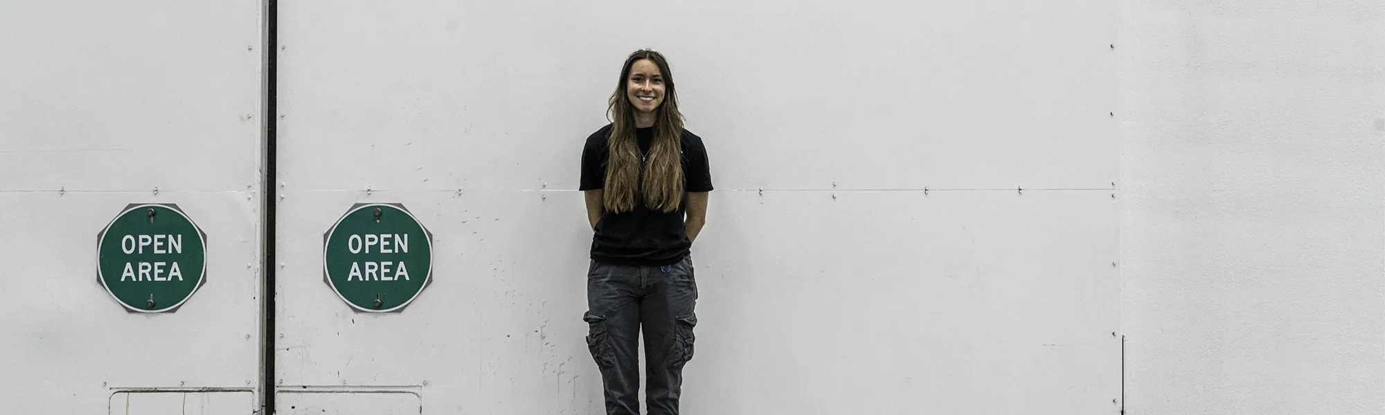 Sascha, production intern, posed in front of the mill doors