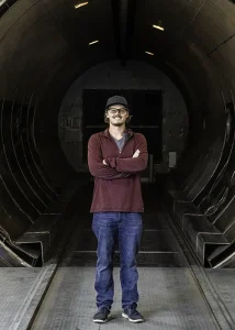 Tyler, cell manager, stands inside a giant autoclave