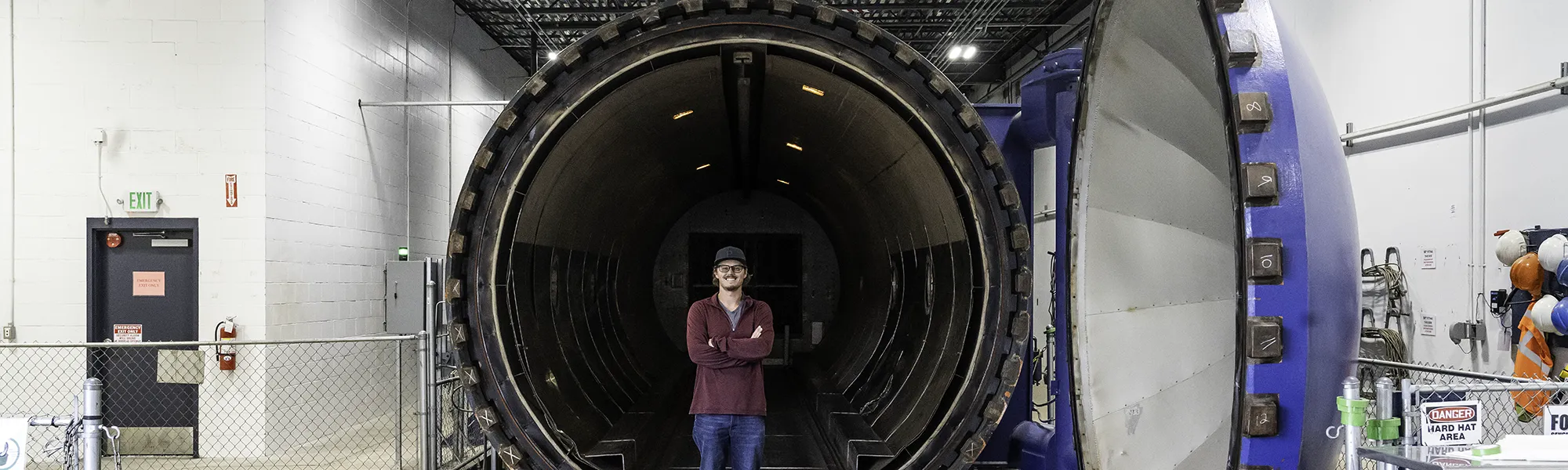 Tyler stands inside the largest autoclave at Janicki
