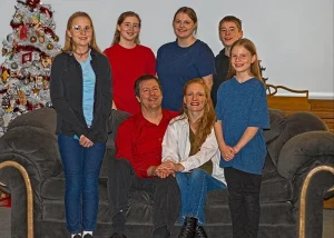 Becky poses for a family photo with her husband and five children