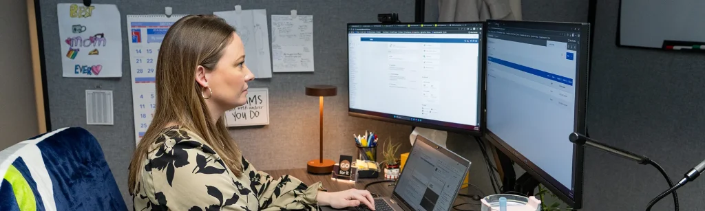 HRIS Analyst. Rebecca, works on a UKR report on her computer