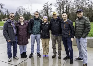 6 Janicki employees pose with Will's parents at the grand opening