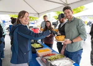 Employee serves food to fellow employee at Cinco De Mayo lunch