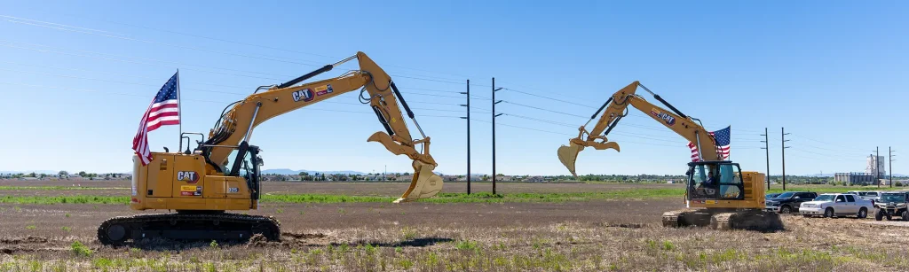 Two yellow CAT excavators breaking ground on Janicki Montana site.