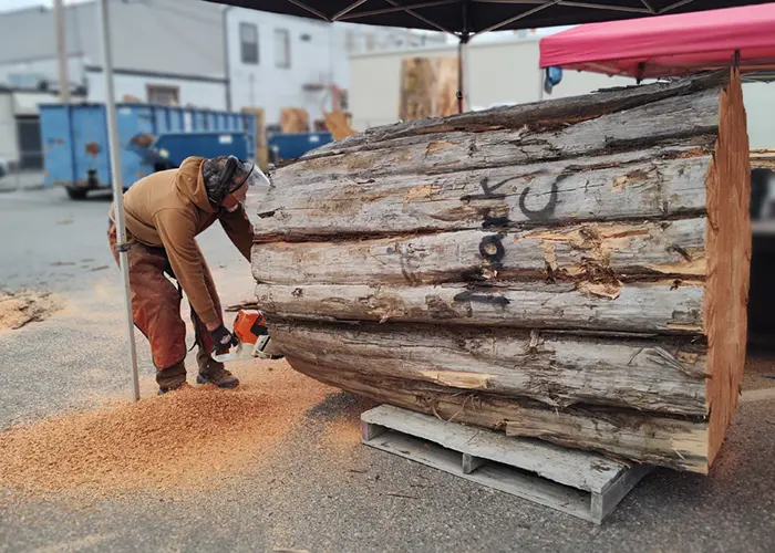 Mark Colp takes a chainsaw to a large log of cedar wood at the Loggerodeo