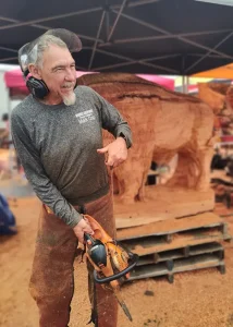 A photo of Mark Colp with chainsaw in hand